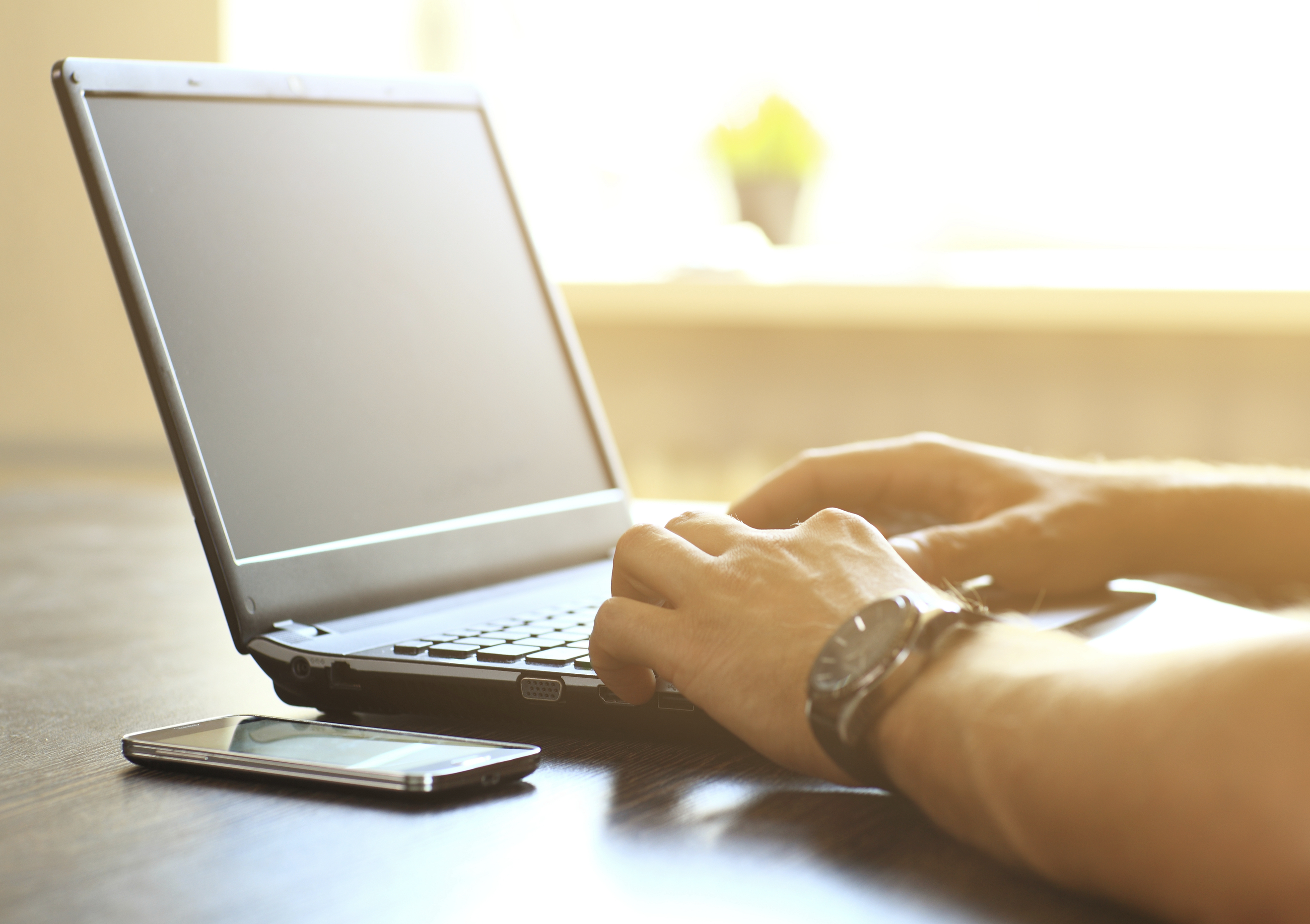 Man's hands typing on laptop keyboard