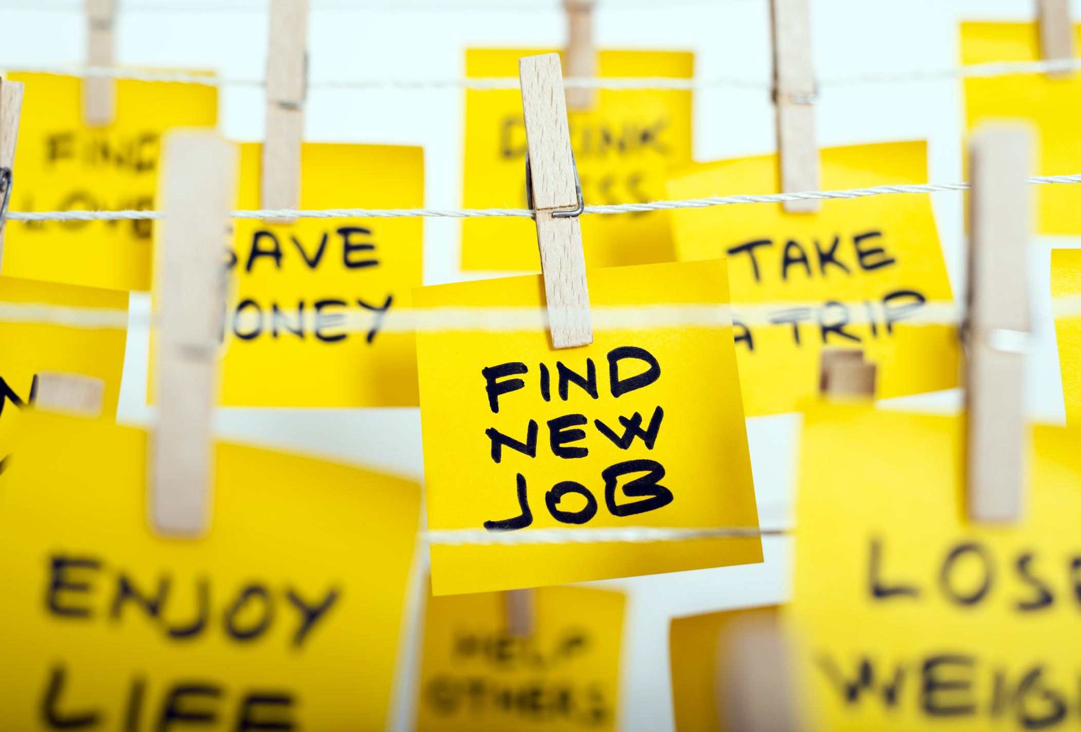 Common New Years resolutions on notes hanging from lines new job openings