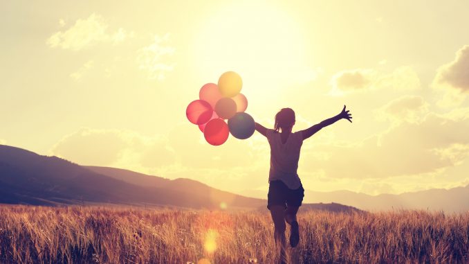 woman on grassland with colored balloons remote jobs