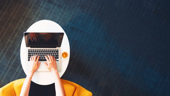 Person working on a laptop computer from overhead remote jobs