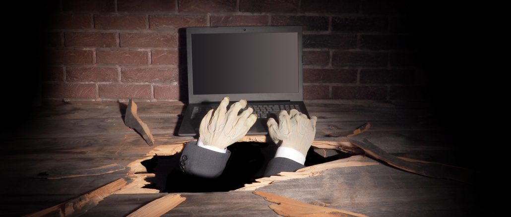 Zombie hand through hole cracked in rustic wood.Halloween theme monster telecommute jobs list