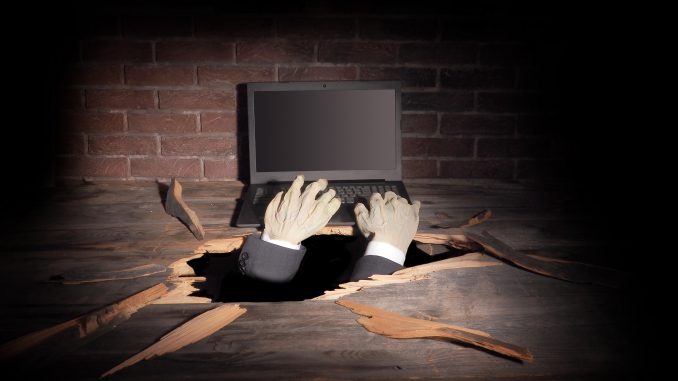 Zombie hand through hole cracked in rustic wood.Halloween theme monster telecommute jobs list