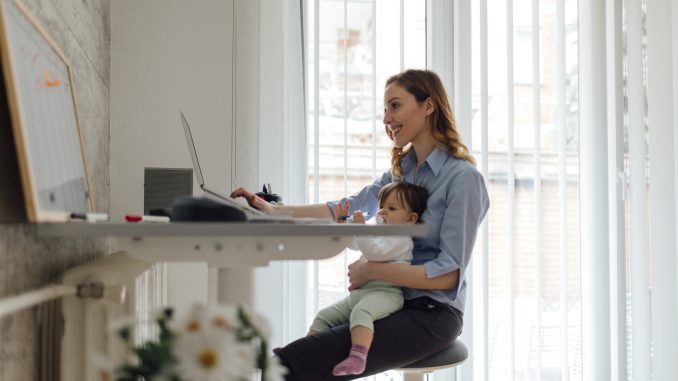 Mother Working from home and holding her baby NWFM Survey Results 2018
