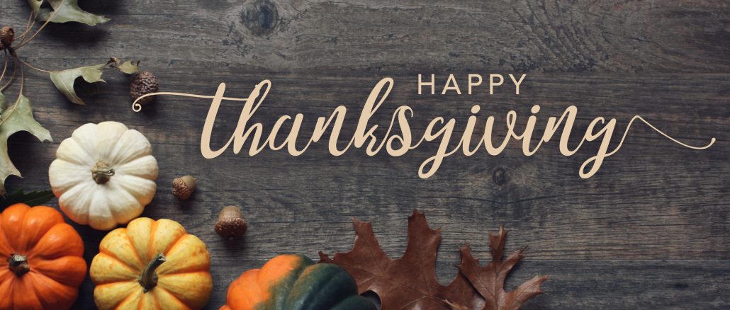 Happy Thanksgiving greeting text with pumpkins, squash and leaves over dark wood background Thanksgiving job leads