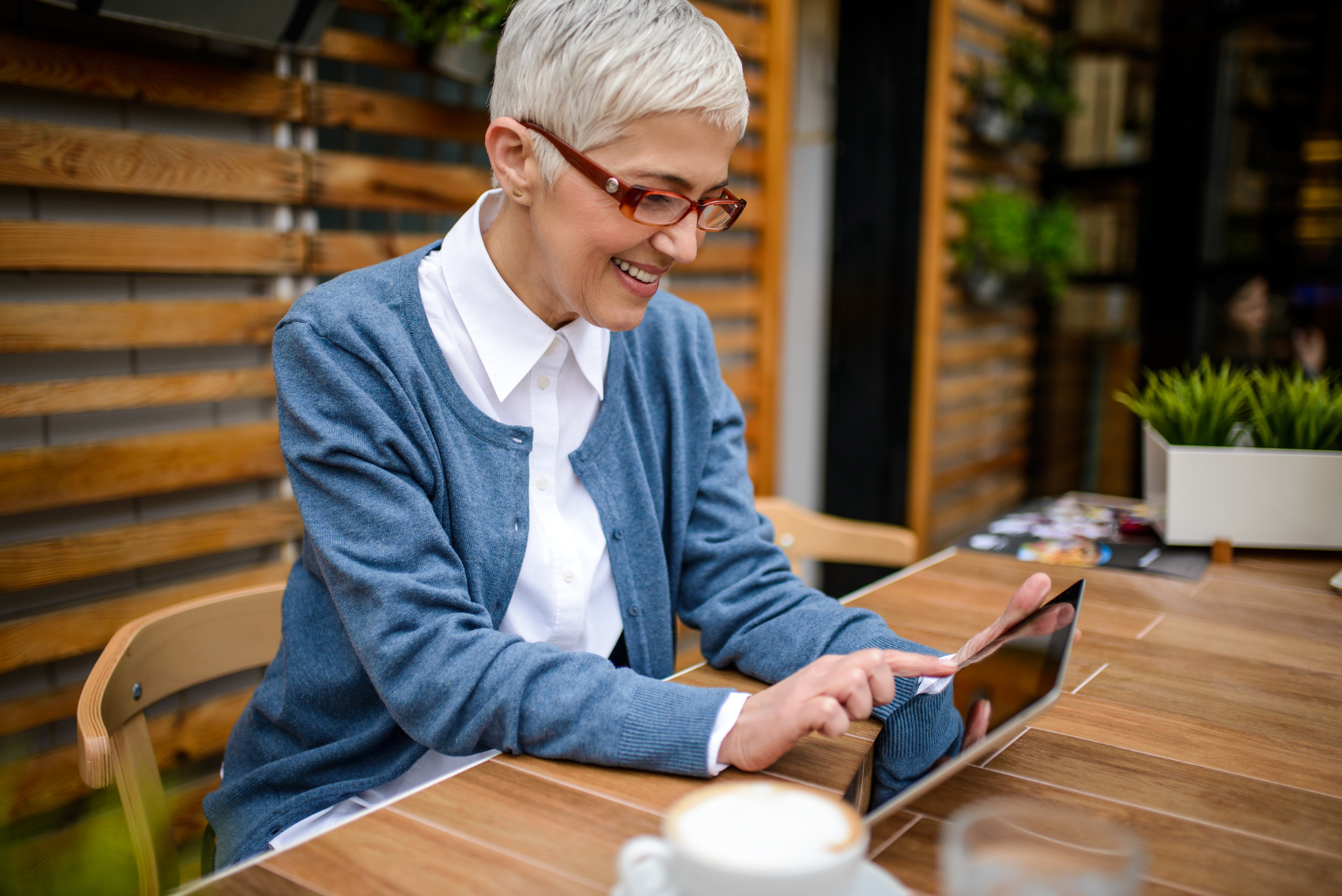 smiling mature professional woman using tablet and drinking coffee - Top 20 Remote Work States in 2018 - Virtual Vocations telecommute and remote jobs