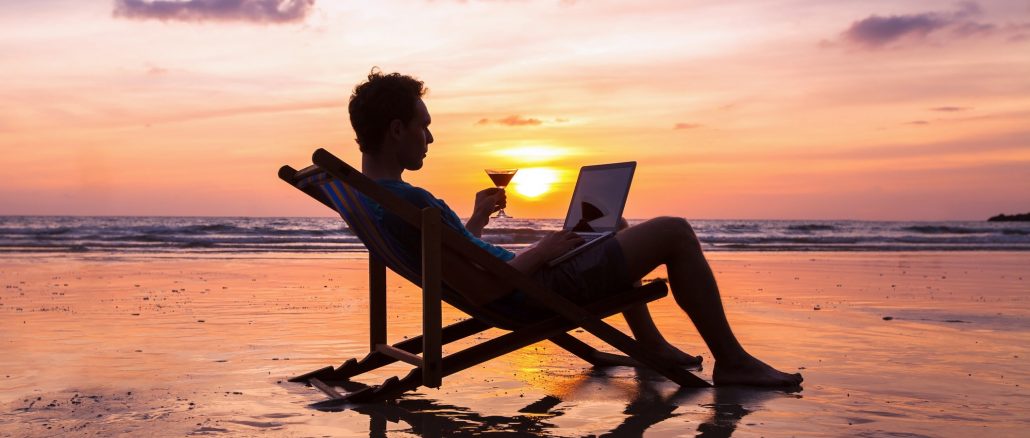 Businessman on beach Reaching financial goals enables freelancers to do what they want, when they want, such as working at the beach.